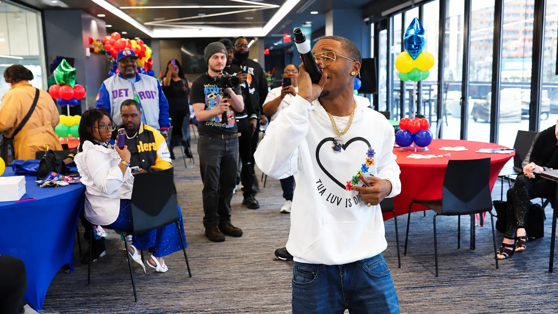 Kid Jay singing into a microphone at an autism-awareness community event